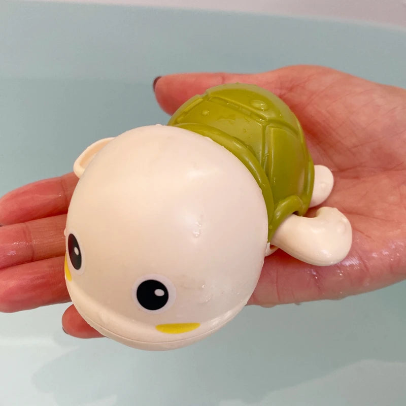 Baby-Badespielzeug, das eine niedliche Schwimmschildkröte badet